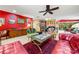 Spacious living room with vibrant red wall, eclectic decor, and open floor plan at 2630 Bucida Dr, Sarasota, FL 34232