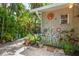 Beautifully landscaped backyard showcases unique decorative elements, artistic wall decor, and lush tropical foliage at 2630 Bucida Dr, Sarasota, FL 34232