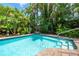 Enjoy the refreshing, clear waters of this backyard pool surrounded by lush, tropical landscaping at 2630 Bucida Dr, Sarasota, FL 34232