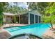 Backyard pool with a screened in lanai and tropical foliage at 2630 Bucida Dr, Sarasota, FL 34232