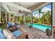 Enjoy outdoor living in this inviting screened porch with a ceiling fan and views of the pool at 2630 Bucida Dr, Sarasota, FL 34232