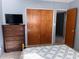 This bedroom has terrazzo flooring, a dresser, wood closet, and modern TV at 2833 62Nd N St, St Petersburg, FL 33710