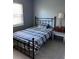 Comfortable bedroom with black metal bed, and a side table with vintage lamp and clock at 2833 62Nd N St, St Petersburg, FL 33710