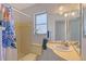 Bathroom featuring a vanity sink and shower with colorful floral shower curtain and bright yellow tiles at 3127 Dawson St, Sarasota, FL 34239