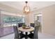 Bright dining area with view to the pool, stylish light fixture, and seating for four at 3127 Dawson St, Sarasota, FL 34239