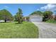 Well-kept lawn, mature trees, and a charming single-story home with attached garage at 3127 Dawson St, Sarasota, FL 34239