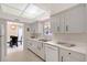 Galley kitchen featuring bright cabinets, and a dishwasher, perfect for meal preparation and cleanup at 3127 Dawson St, Sarasota, FL 34239