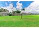 Expansive backyard featuring a lush lawn, privacy fence, and a mix of trees on a sunny day at 3213 Mercer Rd, Bradenton, FL 34207