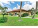 Inviting community clubhouse with a well-maintained lawn and beautiful landscaping in a tropical setting at 3213 Mercer Rd, Bradenton, FL 34207