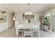 Bright dining area with white table, chairs, and chandelier near decorative wall art at 3213 Mercer Rd, Bradenton, FL 34207