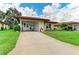 Single-story home with a covered parking area and well manicured landscaping at 3213 Mercer Rd, Bradenton, FL 34207