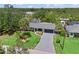 Aerial view of the home showcasing its landscaped yard, screened-in pool, and wooded surroundings at 3500 Liberty St, Port Charlotte, FL 33948