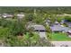Aerial view of a home, landscaping, and neighborhood canal with mature trees surrounded by greenery at 3500 Liberty St, Port Charlotte, FL 33948