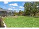 Spacious backyard boasts lush grass, a firepit, and a screened pool area, ideal for outdoor fun at 3500 Liberty St, Port Charlotte, FL 33948