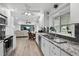 Modern white kitchen featuring granite countertops, stainless steel appliances and an open floorplan at 3500 Liberty St, Port Charlotte, FL 33948