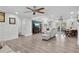 Open-concept living room with a large TV, dining area, and access to the outdoors at 3500 Liberty St, Port Charlotte, FL 33948