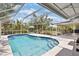 Relaxing screened in pool with water feature, wading steps, and a spacious area for lounge chairs at 3500 Liberty St, Port Charlotte, FL 33948