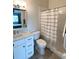 Bright bathroom featuring a white vanity with marble countertop and a shower with striped curtain at 396 Countryside Key Blvd, Oldsmar, FL 34677