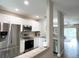 Modern kitchen with stainless steel appliances, white cabinets, and an open view of the living area at 396 Countryside Key Blvd, Oldsmar, FL 34677