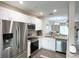 Well-equipped kitchen featuring stainless steel appliances, granite countertops, and white cabinets at 396 Countryside Key Blvd, Oldsmar, FL 34677