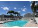Community pool surrounded by lounge chairs, palm trees, and well-maintained buildings at 396 Countryside Key Blvd, Oldsmar, FL 34677