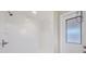 Bathroom shower with white tiling and a glass door at 408 Fletcher St, Port Charlotte, FL 33954