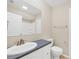 Well-lit bathroom featuring a single sink vanity with a gray countertop and a large mirror reflecting the shower and commode at 408 Fletcher St, Port Charlotte, FL 33954