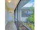Covered entryway featuring a secure screen door, tiled floor, and partial landscaping at 408 Fletcher St, Port Charlotte, FL 33954