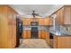 Well-lit kitchen with wood cabinets, black appliances, and tile backsplash at 408 Fletcher St, Port Charlotte, FL 33954