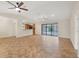 Open-concept living room with tile flooring, ceiling fans, and sliding doors with a pool view at 408 Fletcher St, Port Charlotte, FL 33954