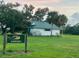 Quaint home with green roof, set in a lush landscape of trees and green grass at 4353 Hidden River Rd, Sarasota, FL 34240