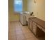 Bright laundry room with tile floor, large capacity washing machine, and countertop workspace at 4353 Hidden River Rd, Sarasota, FL 34240
