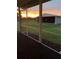 View from a screened porch, looking out to a large barn and pasture at sunset at 4353 Hidden River Rd, Sarasota, FL 34240
