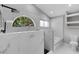 Modern bathroom features a walk-in shower, soaking tub, large windows, and marble-look tiling at 4473 Diamond S Cir, Sarasota, FL 34233