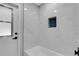 Bathtub featuring marble-like tile surround and a blue tile accent niche at 4473 Diamond S Cir, Sarasota, FL 34233
