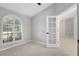 Bedroom with a window featuring shutters, a ceiling fan, and a modern doorway at 4473 Diamond S Cir, Sarasota, FL 34233