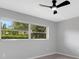 Bedroom with view to lush backyard, ceiling fan, and neutral wall-to-wall carpeting at 4473 Diamond S Cir, Sarasota, FL 34233