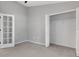 Neutral bedroom with tall ceiling, open closet, and white French door at 4473 Diamond S Cir, Sarasota, FL 34233