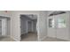 Hallway with doorways leading to rooms, carpeted bedroom is shown at the end of the hall, glass doors to the right at 4473 Diamond S Cir, Sarasota, FL 34233