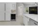 Stylish kitchen with white cabinetry, stainless steel appliances, a wine fridge and tile flooring at 4473 Diamond S Cir, Sarasota, FL 34233