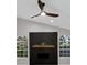 Modern living room featuring a fireplace, stylish ceiling fan, and bright arched windows at 4473 Diamond S Cir, Sarasota, FL 34233
