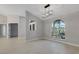 Bright and open living room with tile floors, light walls, arched window and sleek modern light fixture at 4473 Diamond S Cir, Sarasota, FL 34233