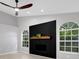 Modern living room with a black accent wall, fireplace, and arched windows at 4473 Diamond S Cir, Sarasota, FL 34233