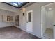 Covered patio with gray walls, brick flooring, and pass-through window to inside at 4473 Diamond S Cir, Sarasota, FL 34233