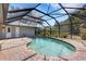 Backyard pool area with a screen enclosure, brick patio, and well-maintained landscaping at 4473 Diamond S Cir, Sarasota, FL 34233