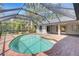 Private backyard oasis with enclosed pool, brick patio, and lush tropical landscaping at 4473 Diamond S Cir, Sarasota, FL 34233