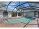 Enclosed pool area with brick patio, screen enclosure, blue pool, and backyard views at 4473 Diamond S Cir, Sarasota, FL 34233