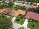 Aerial view of a property surrounded by lush greenery, showcasing a red tile roof and a sparkling pool at 4492 Del Sol Blvd, Sarasota, FL 34243