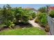 Beautifully landscaped backyard with a gravel path, lush plants, and a glimpse of the home's exterior at 4492 Del Sol Blvd, Sarasota, FL 34243