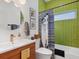 Bathroom featuring green tile, modern fixtures, and a stylish vanity at 4492 Del Sol Blvd, Sarasota, FL 34243